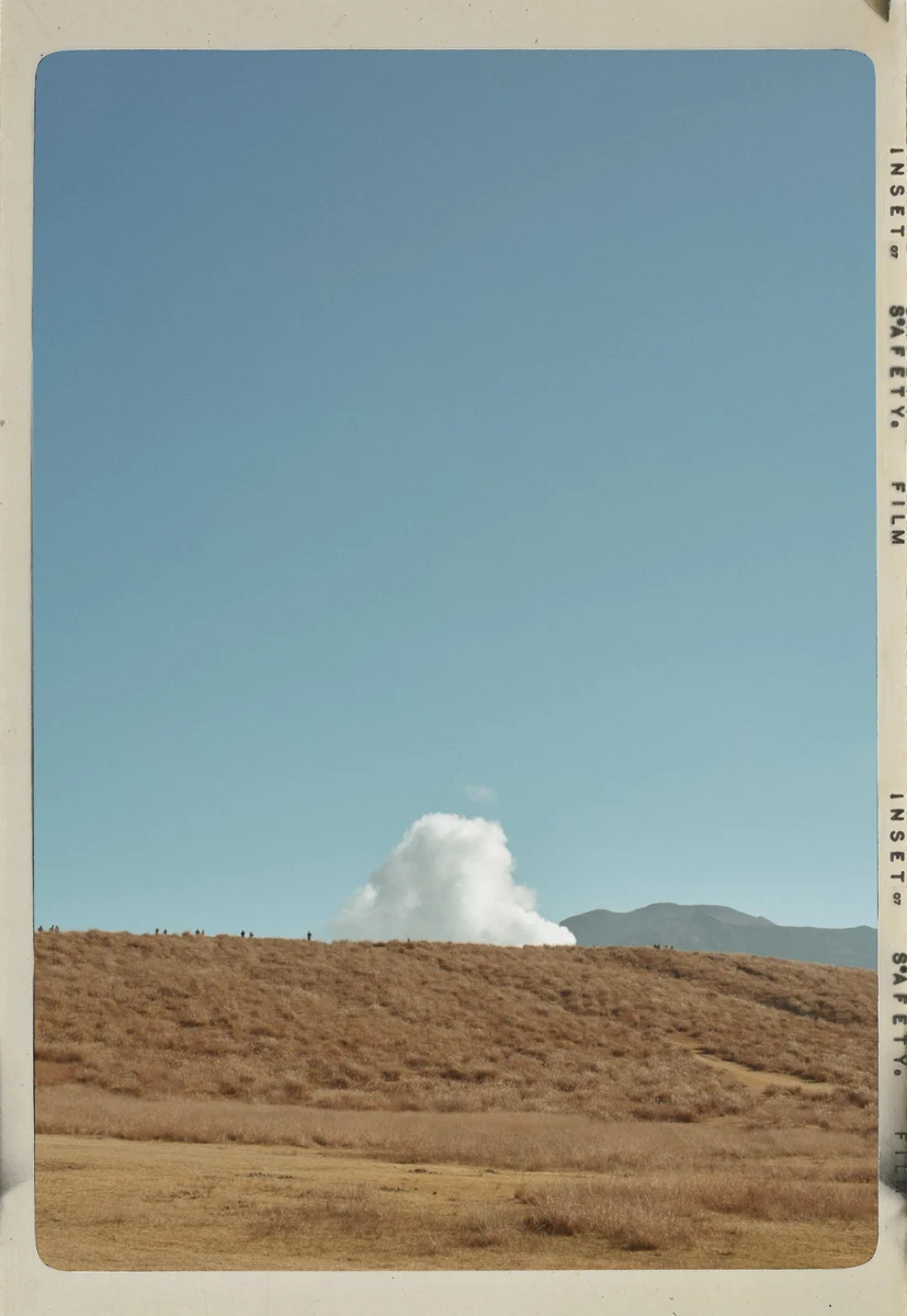 A field and plume of steam in a white film frame