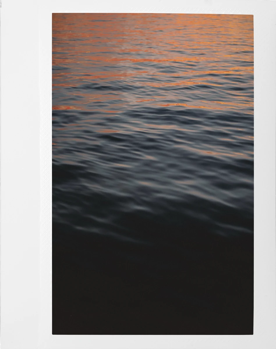 Sunset light on water in a white polaroid frame